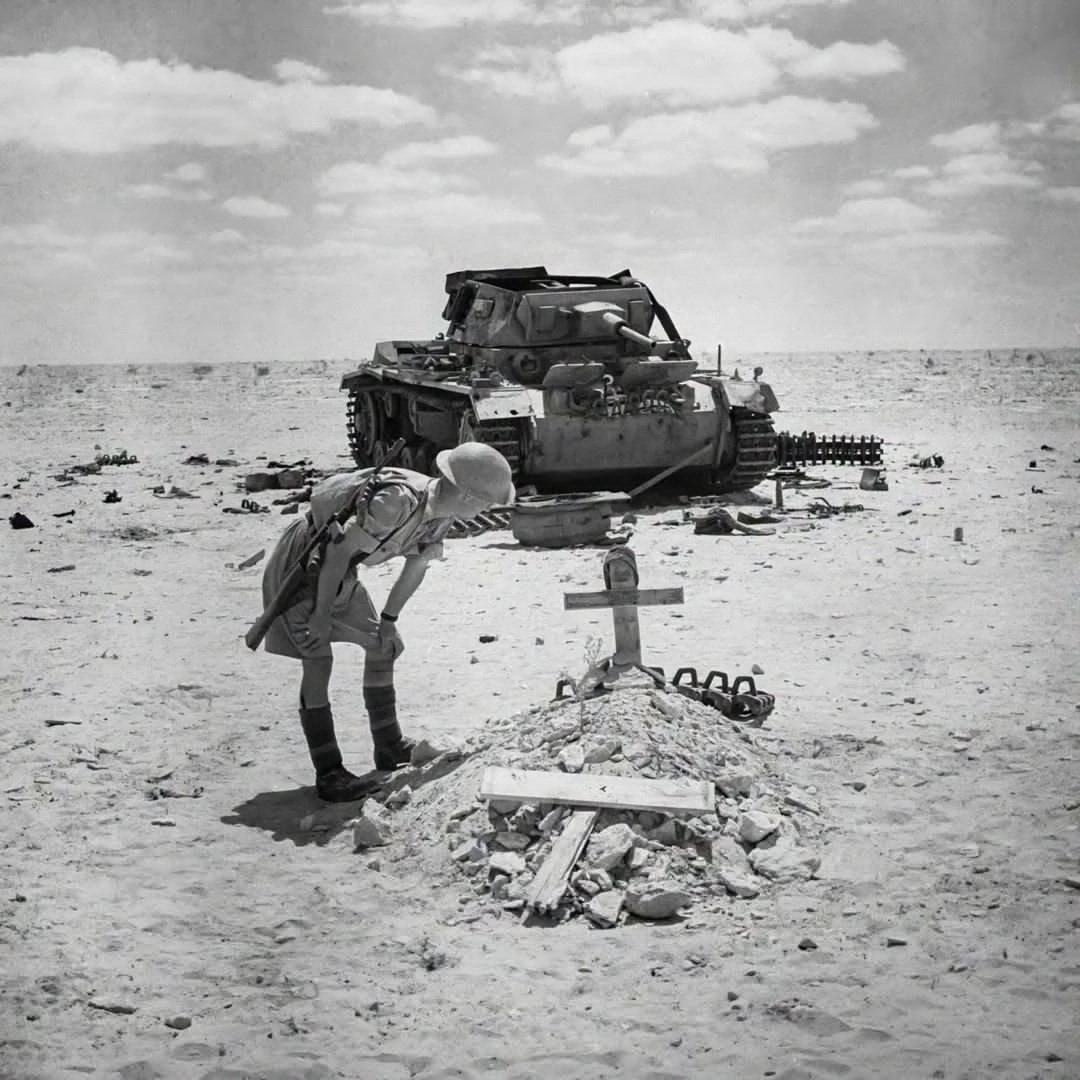1942年9月29日，一名士兵正在查看一具德国坦克乘员的墓碑。这名乘员在西非沙漠