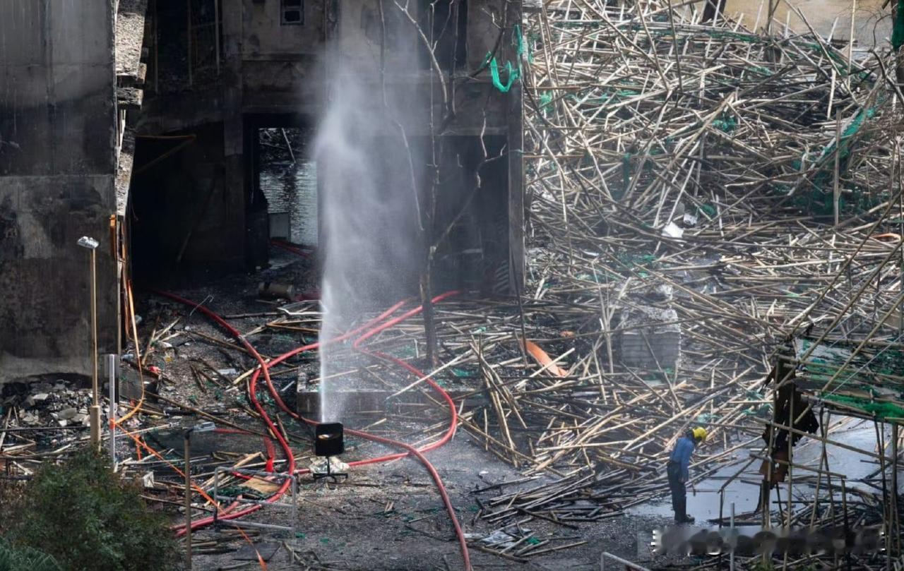 一名消防员向同袍何伟豪殉职的位置鞠躬。