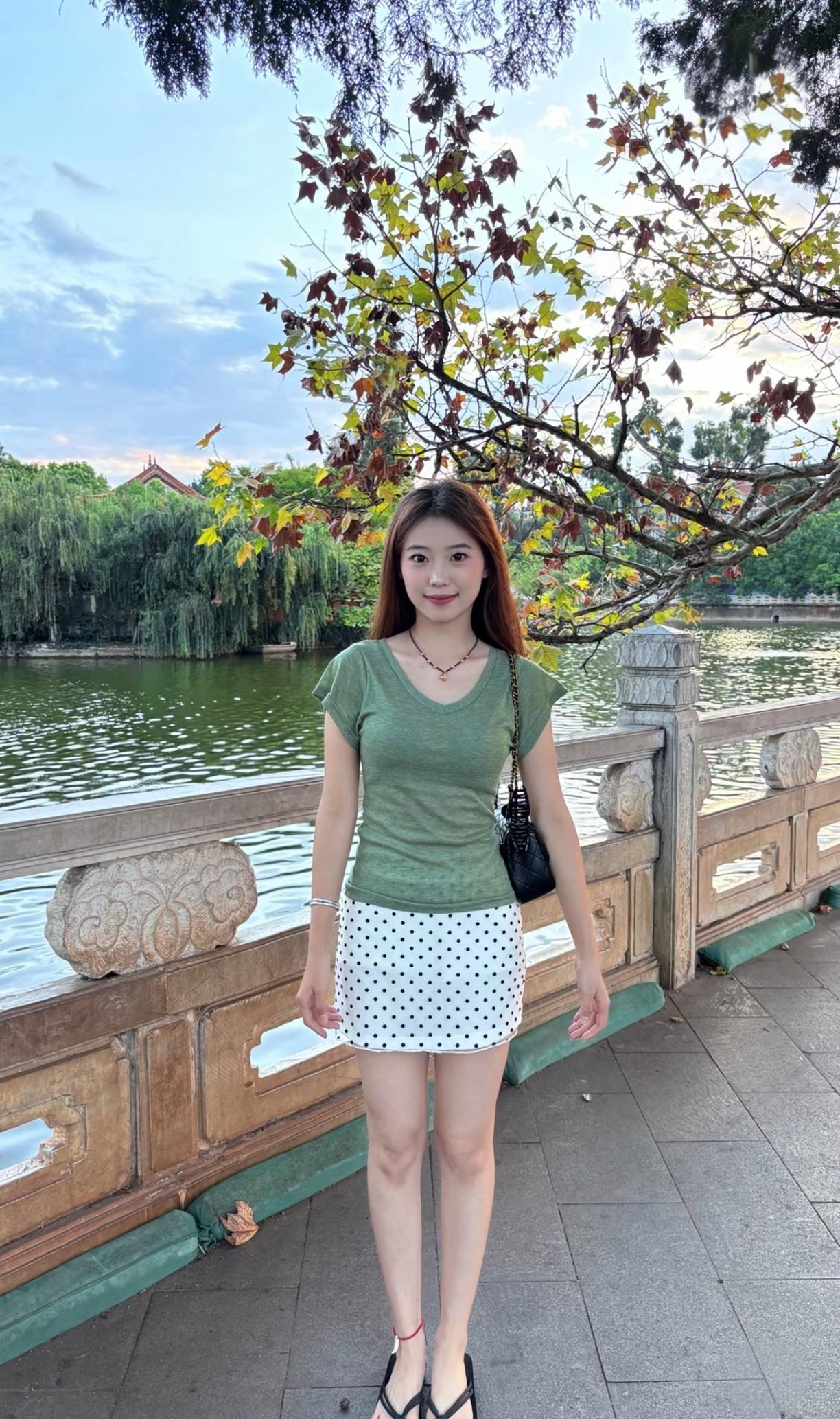 漂亮女孩在桥边拍照。