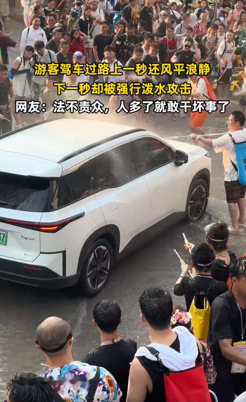 这样的泼水节已经变味了！云南泼水节，一辆辽A的白色新能源车路过，前一秒大家还只是