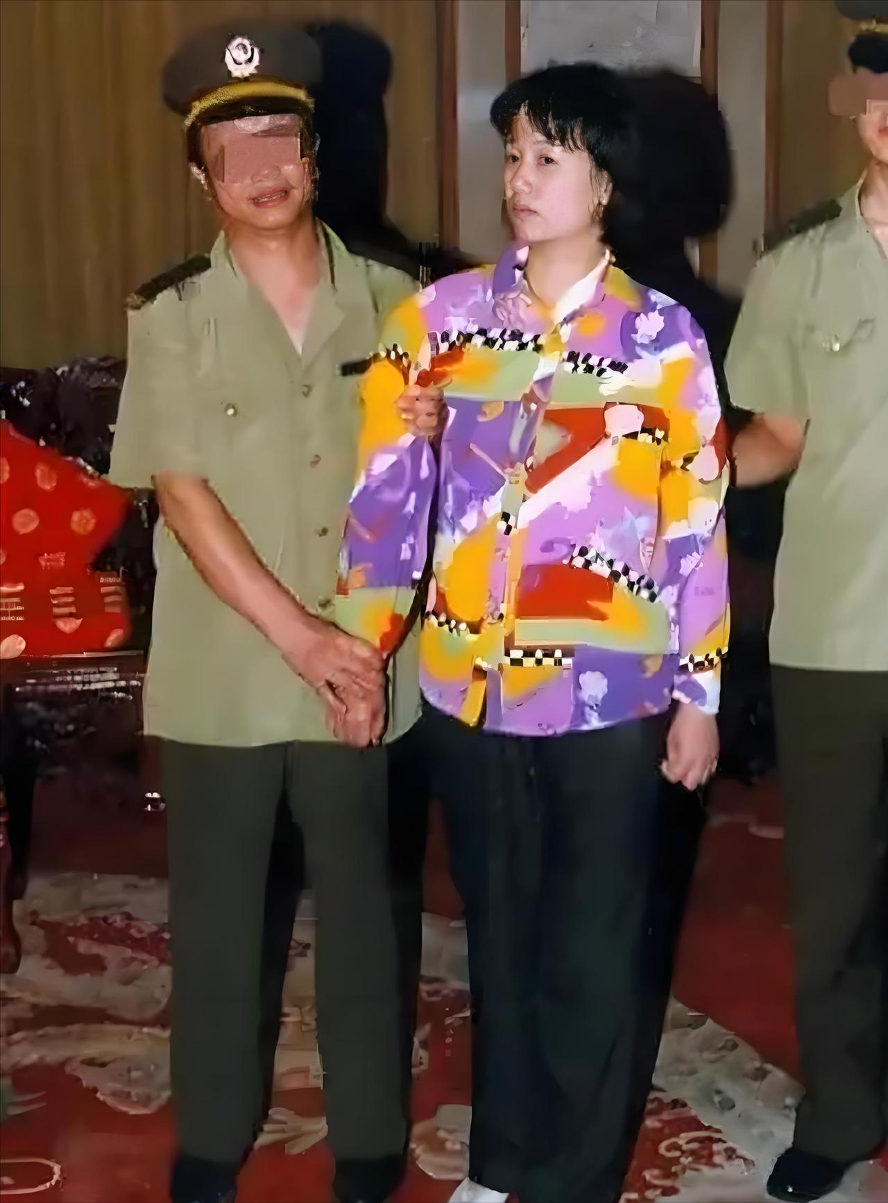 2000年，刘艺霞被判死刑，照片中的她，身穿花衬衫，被两名警察押送着，面无表情，