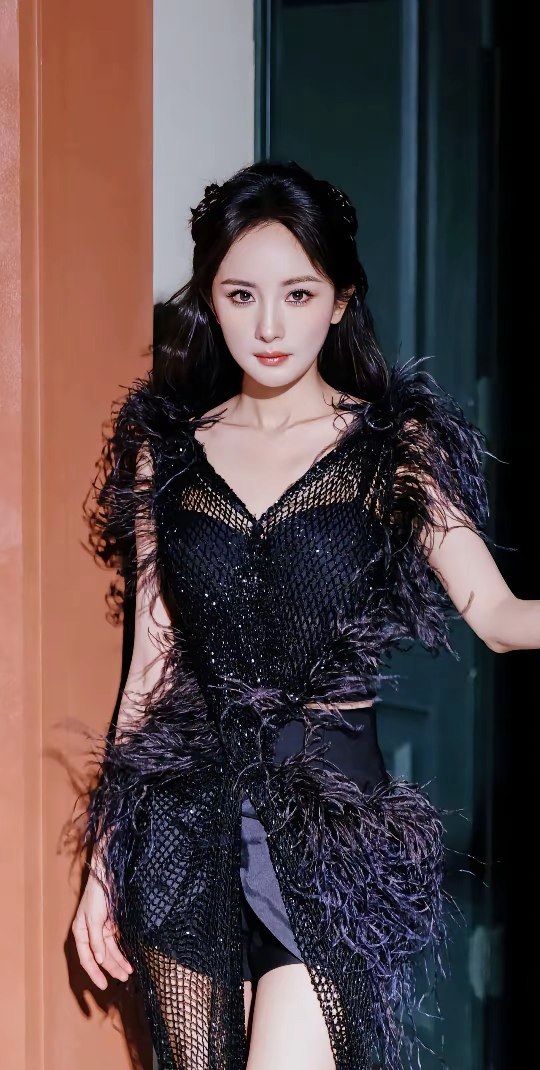 杨幂一袭羽毛高定礼服亮相，后背设计大胆吸睛，完美展现优雅气质。这身造型将她的身材