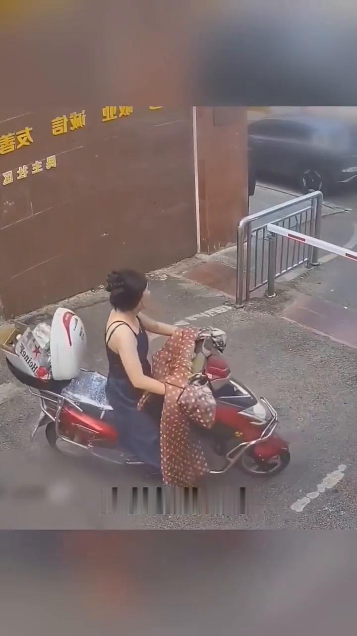 穿吊带裙的小姐姐准备从这里出去，现在栏杆没有抬起来，小姐姐的后备箱也没有盖好，胸