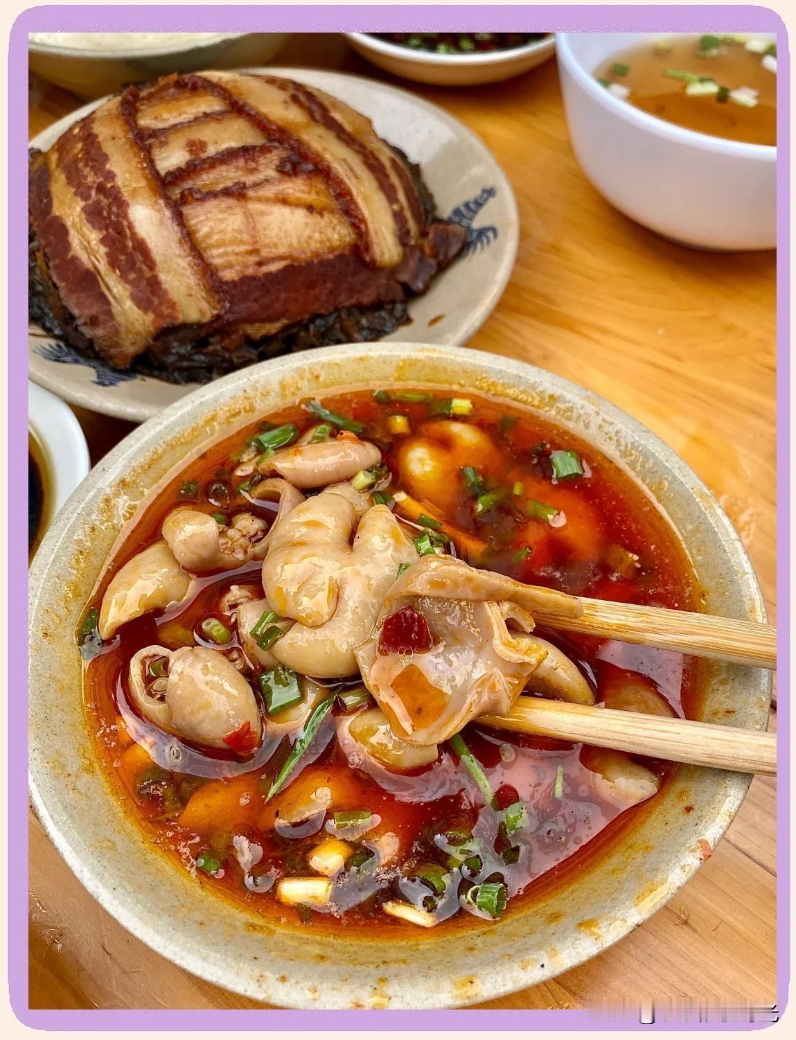 肥肠烧得软糯，赭红色的浓汤，咕嘟着小小的泡，肥肠切成匀称的段，像一个个吸饱了汤汁