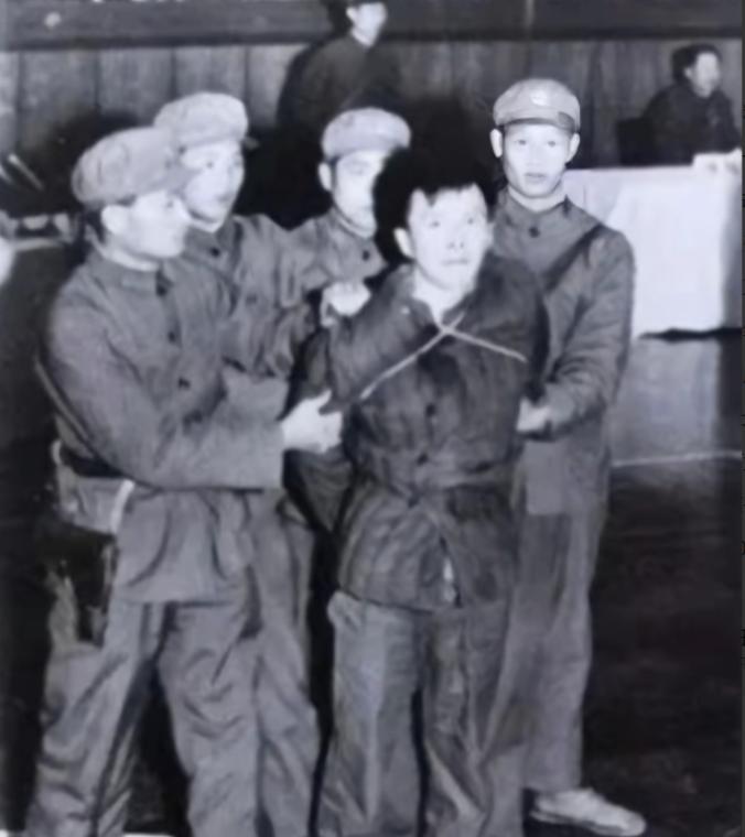 1979年，杭州体育场公审大会，几名执法人员合力按住一个壮实男子，他还在拼命挣扎