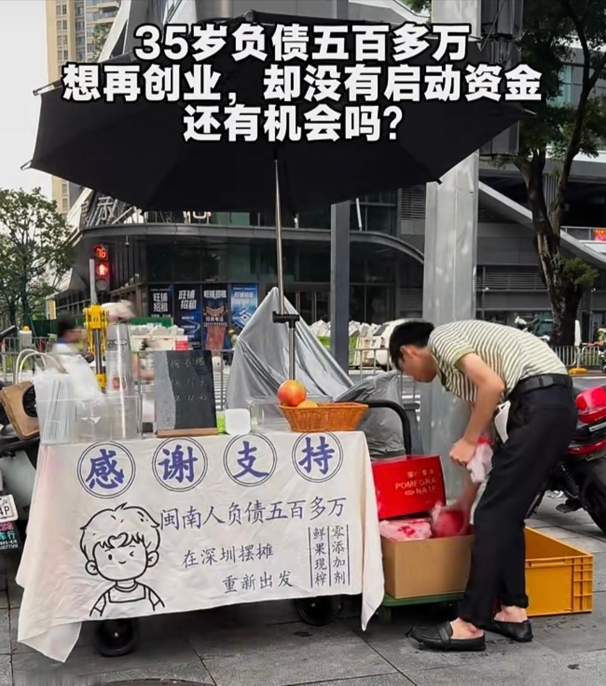 深圳街头，一名小伙摆摊卖果汁，摊位挂出横幅，写着欠债500多万，摆摊创业重新出发