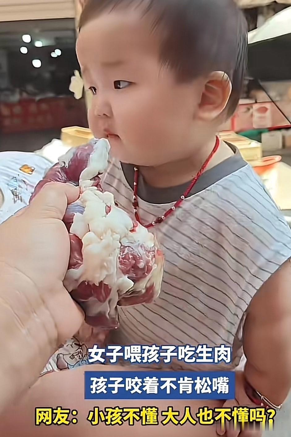 这是什么情况？女子喂孩子吃生肉，孩子咬住不肯松嘴，抱孩子的也不阻止。我敢打赌