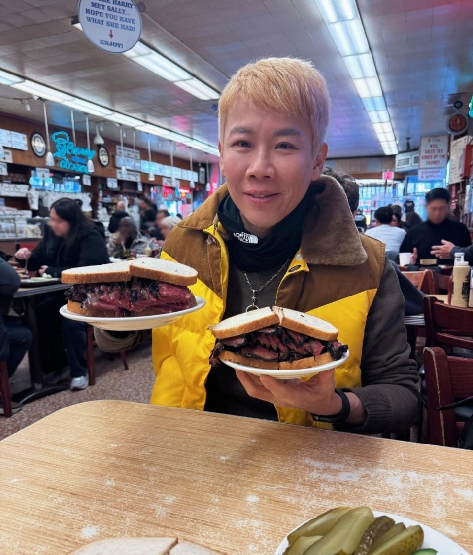 56岁陶喆在美国餐馆吃牛肉汉堡的图片，他染了黄毛，穿着黄棕相间外套。整张脸看起来