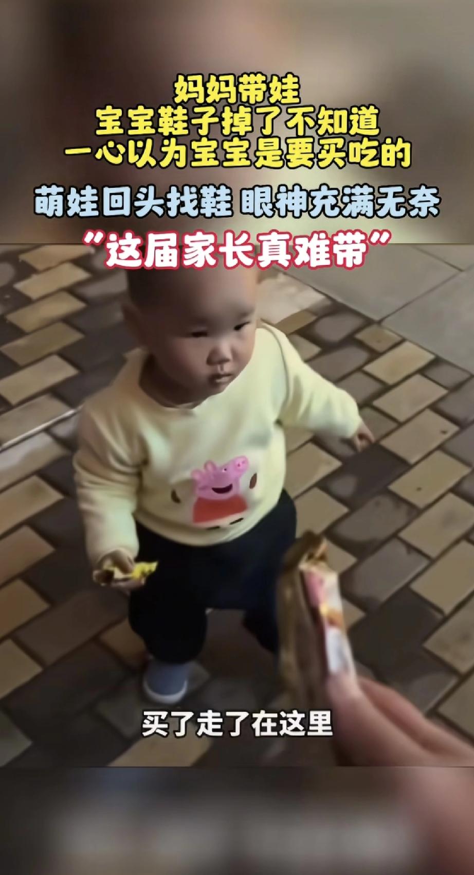 妈妈带娃逛街，宝宝鞋子掉了浑然不知，孩子站着不走，手指指向鞋子掉的地方，妈妈还一