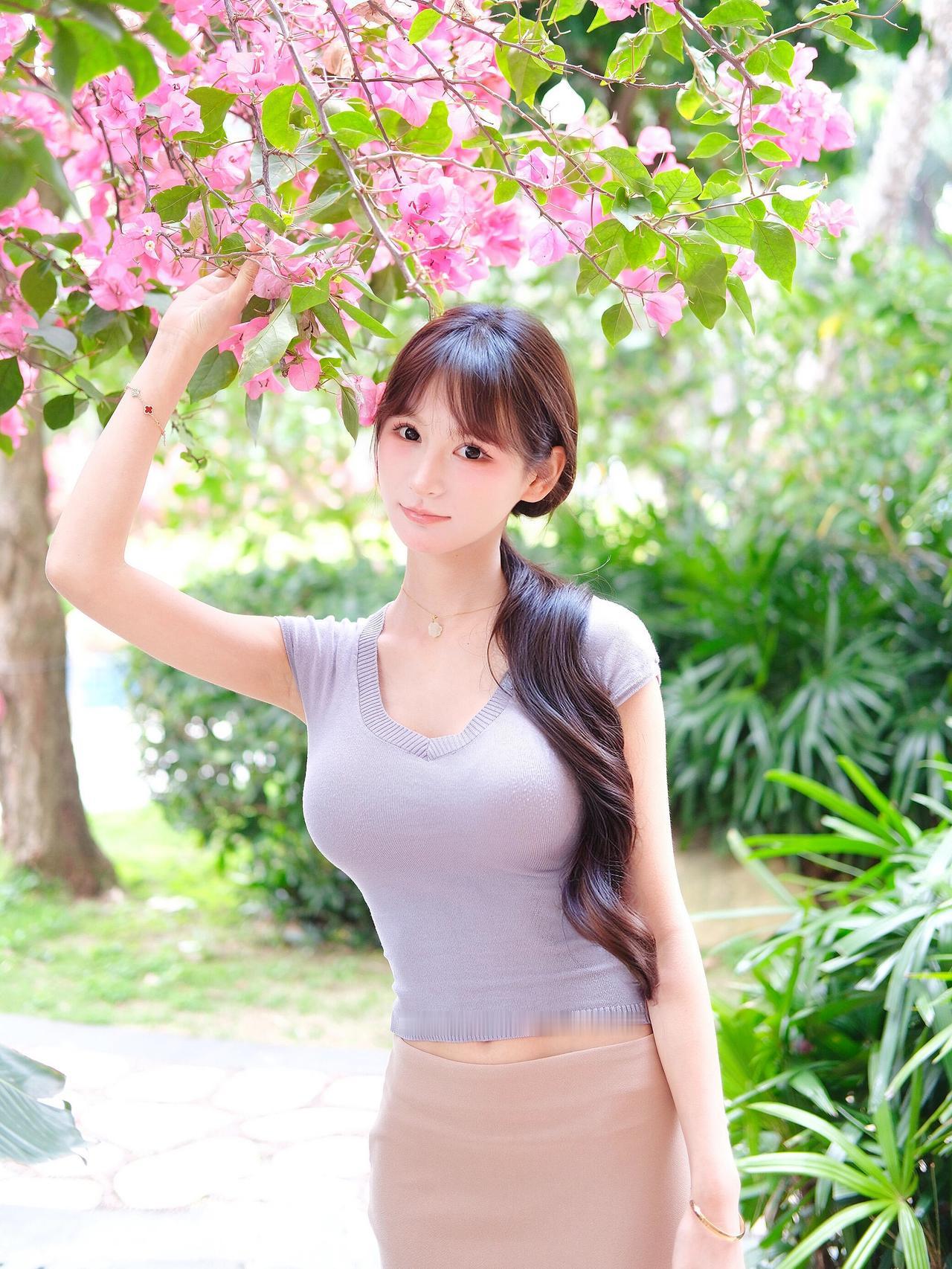 绯霞漫染枝头软，花也嫣然，人也嫣然。鬓畔轻红，相映两婵娟。清风拂过香盈