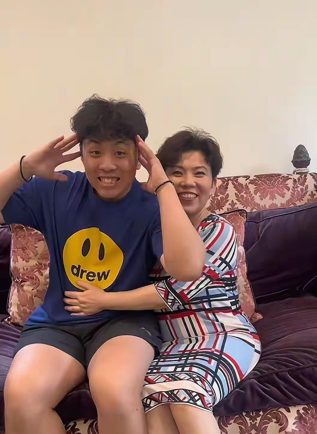 刷到邓亚萍的消息，差点没认出那个坐在花裙子妈妈身边的大小伙子！52岁的邓亚萍穿着