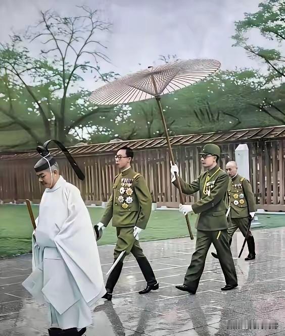 跟随溥仪前后的人，包括打伞的，穿着打扮感觉都像是日本鬼子，溥仪的出行看着有点派头