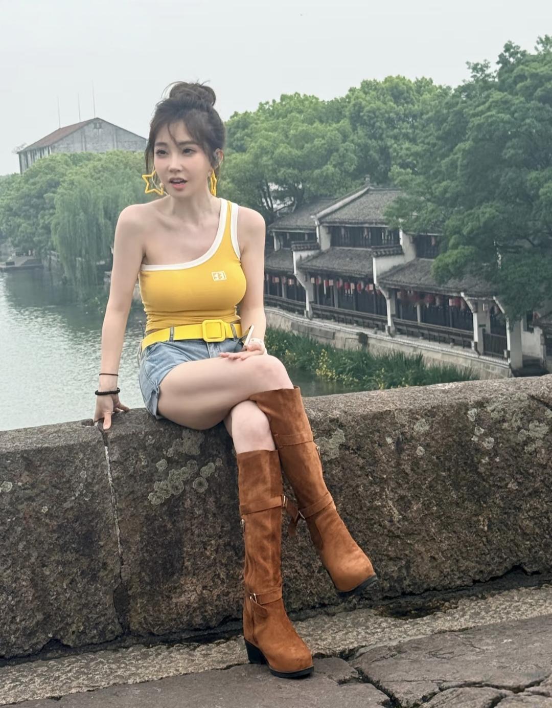 35岁女网红冯提莫在杭州塘栖古镇桥头被偶遇，她的穿衣打扮大胆火辣，露出双肩和双腿