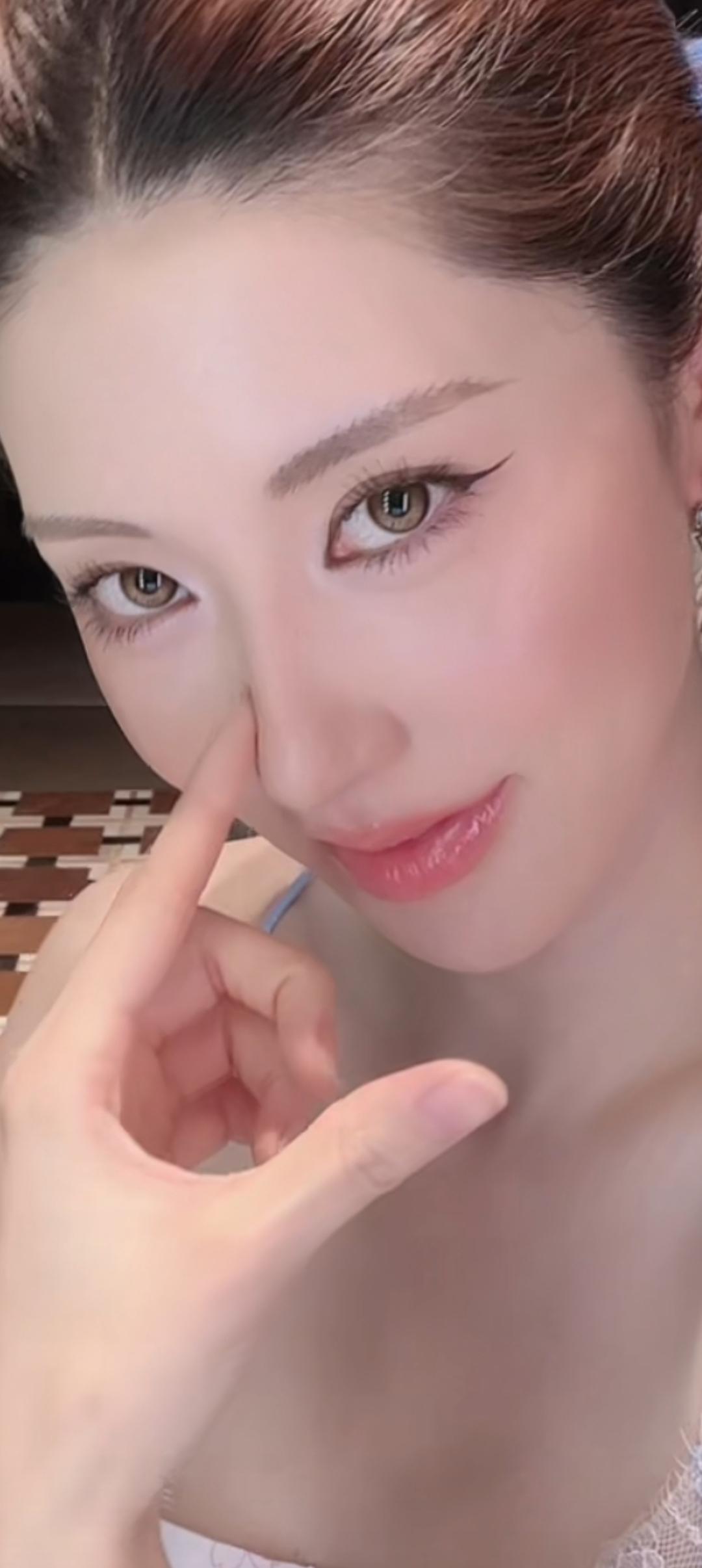 这位美女在轻轻捏自己的脸呢。