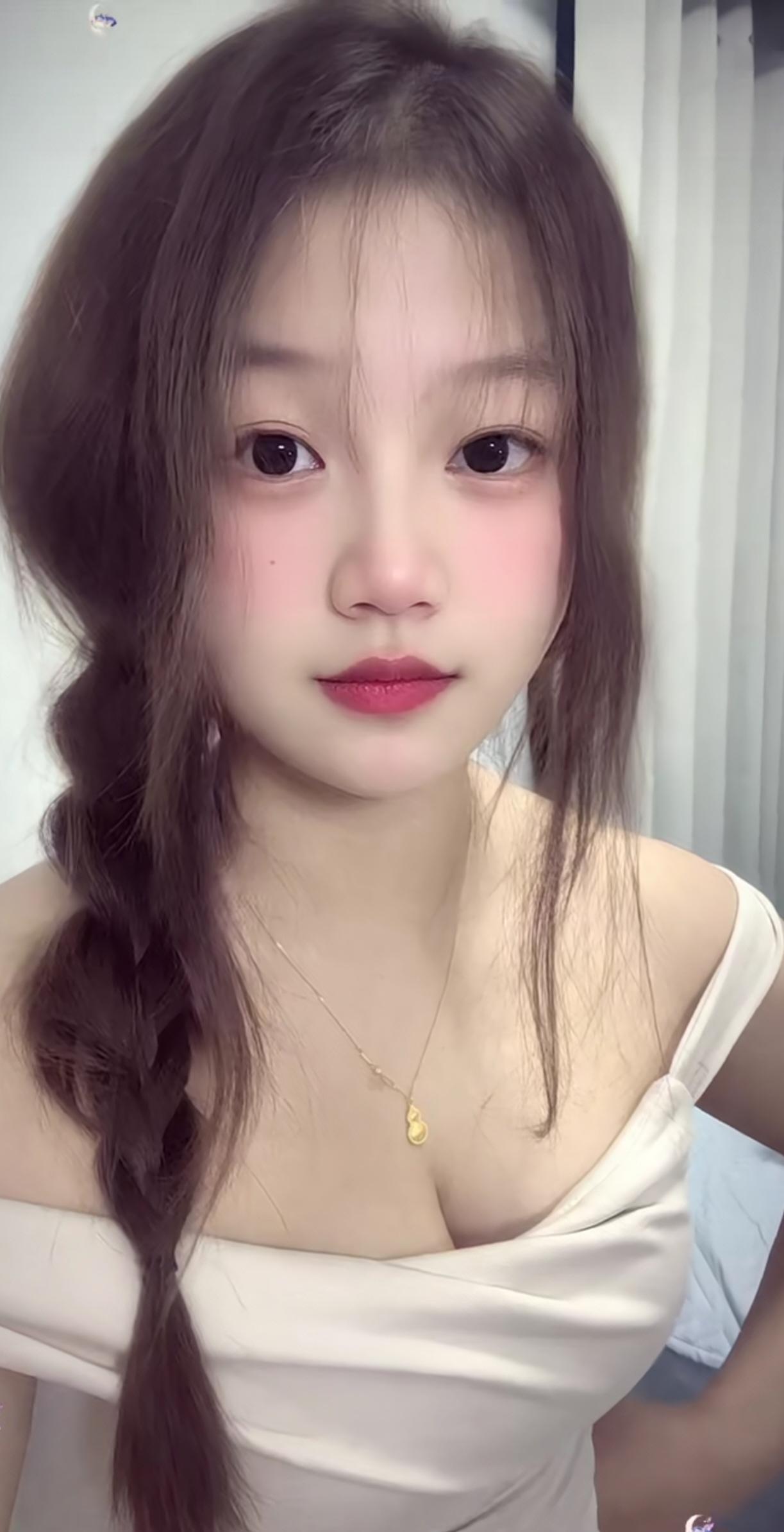小女生买了一条项链戴上拍照。