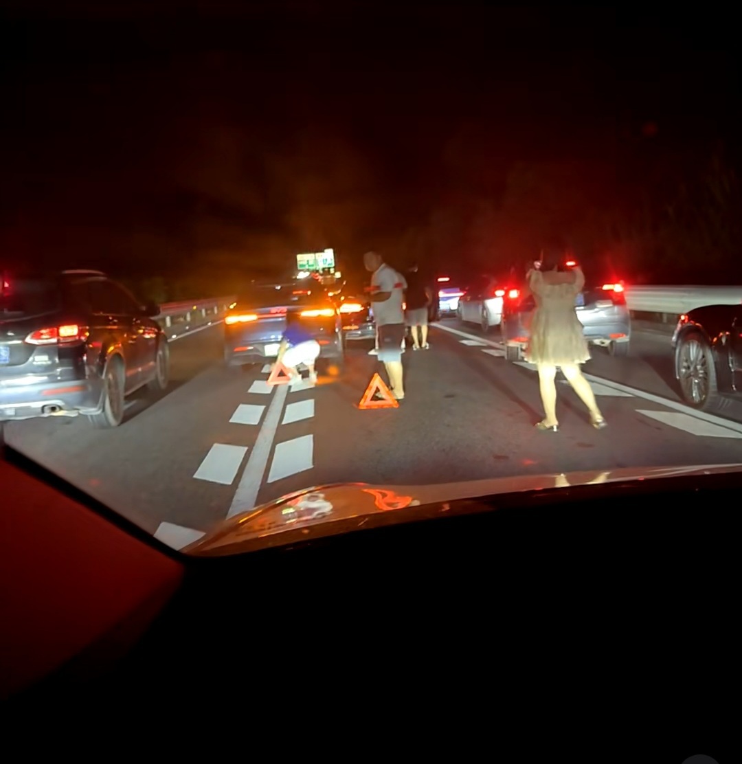 高速实线变道追尾前车，三角警示牌放在车后面10厘米，人还在车后面逗留。你说他不懂