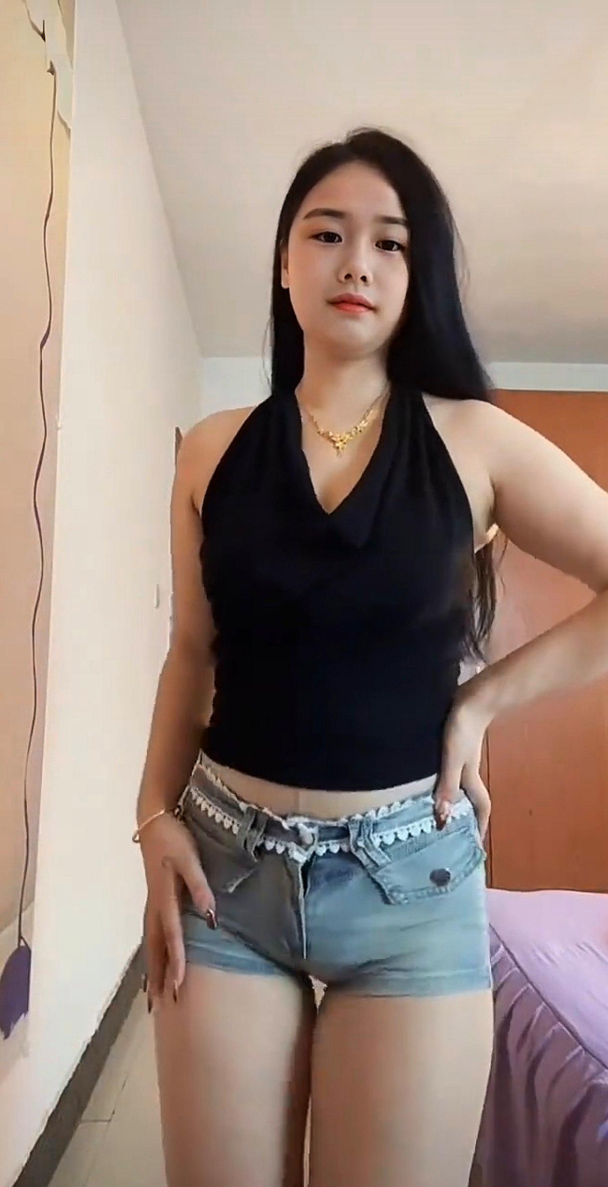 穿黑色背心和牛仔短裤的女生。