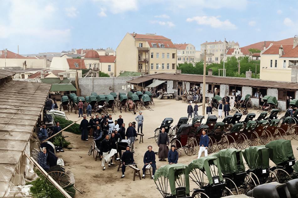 这是一张拍摄于清末至民国初年的青岛黄包车站，照片从高处俯瞰一个宽阔的空地，四周停