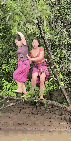 后面红衣服的女子劲儿还是够大的，硬生生的把前面的女子和她给晃动到下面的水里了。