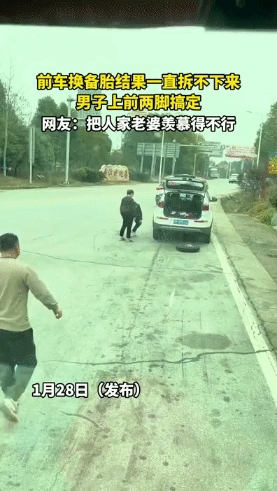 男子给自己车换备胎，可螺丝拧下来后却一直卸不掉，正发愁时，后边一货车司机下车走了