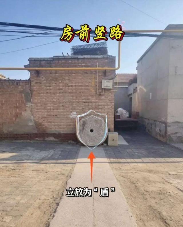 看到一户人家在房前竖路中间立了个石磨盘，太绝了！这路直冲房子，一般算风水不好，但