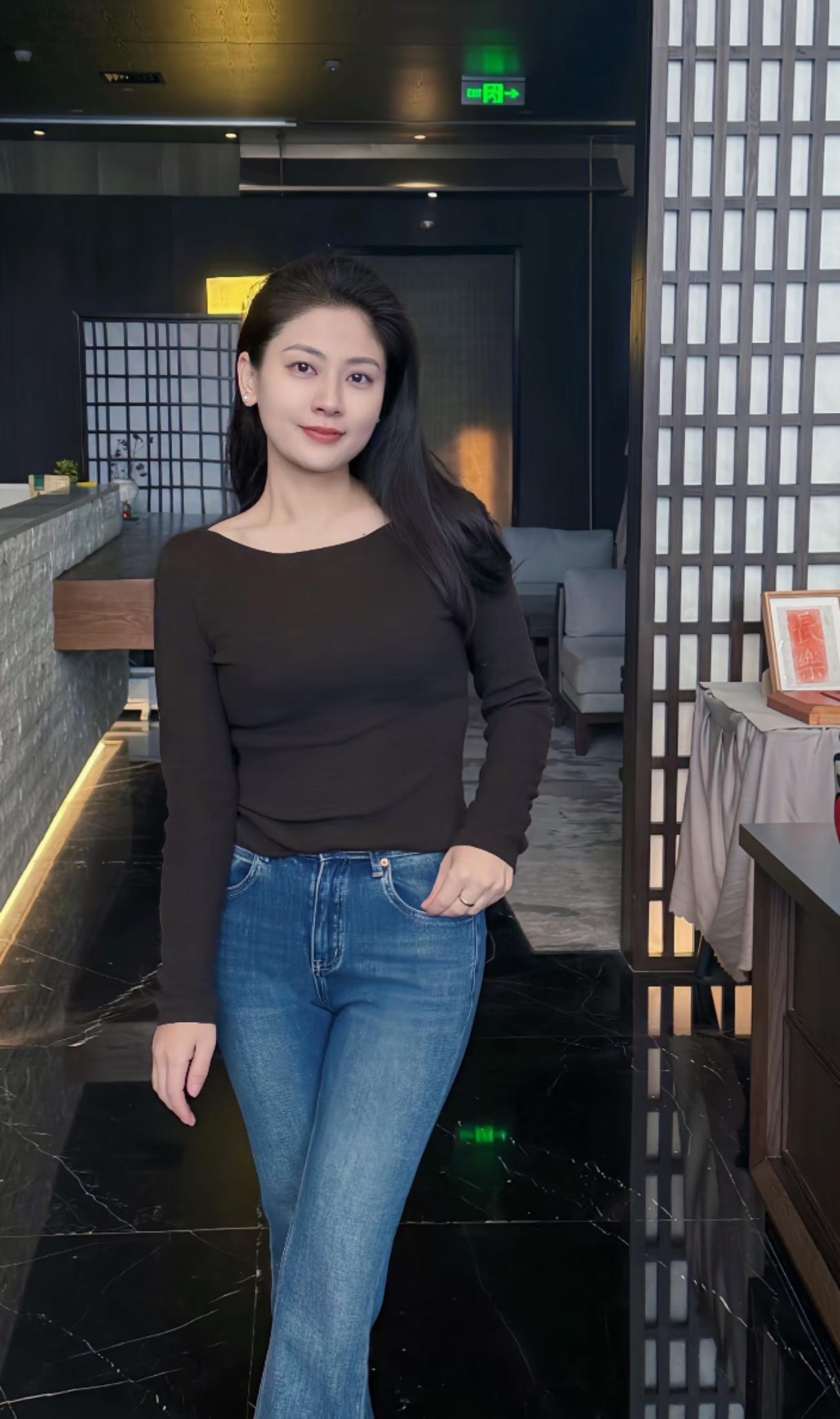 黑衫与牛仔的中式静隅站在中式格栅旁的那一刻黑色针织衫的纹路贴着肩背，软乎