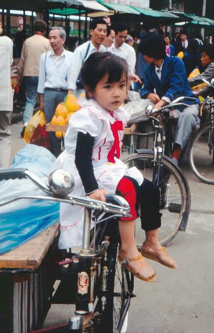 1986年，江苏，苏州。坐在自行车上的小女孩。