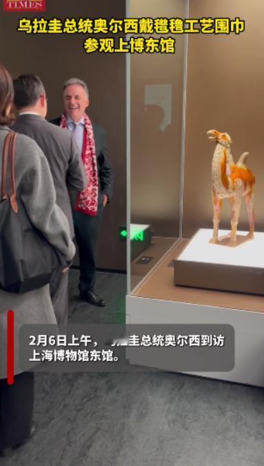 乌拉圭总统访华第六天继续逛上海，换了一身西服与领带，脖子里还围着红色打底印花围巾