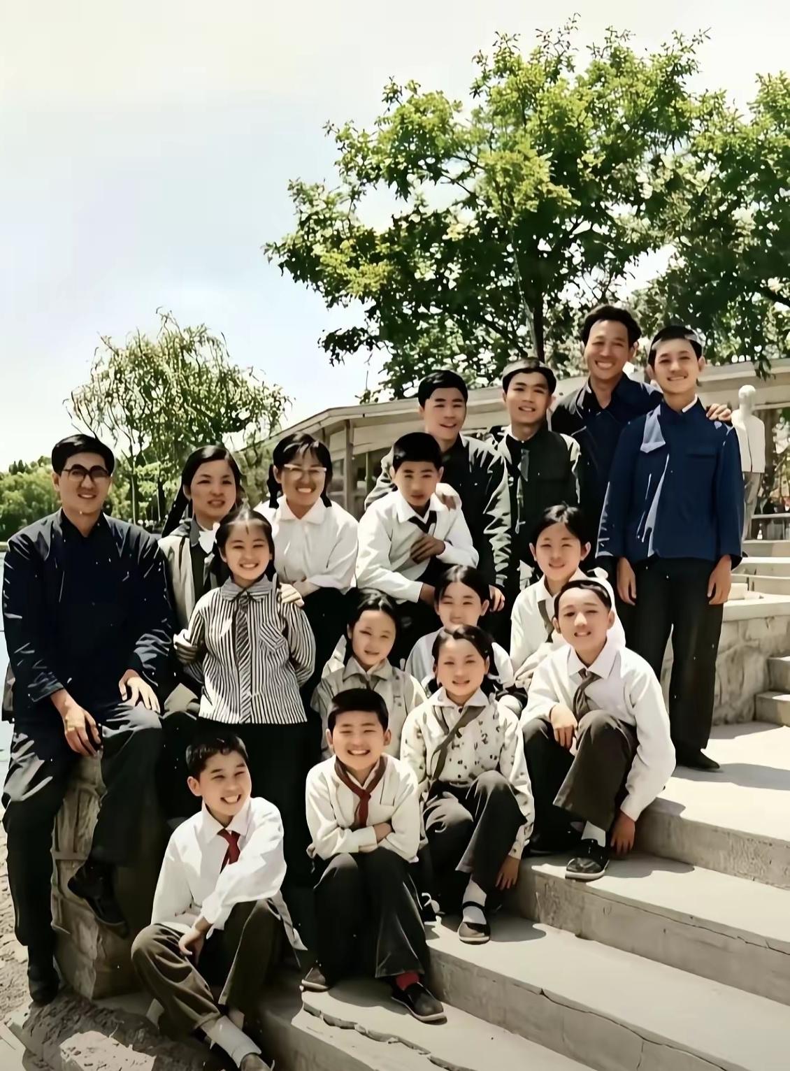 翻到旧相册里一张刘欢老师早年和师生的合影，他穿着很简单，白色上衣黑色裤子，系着红