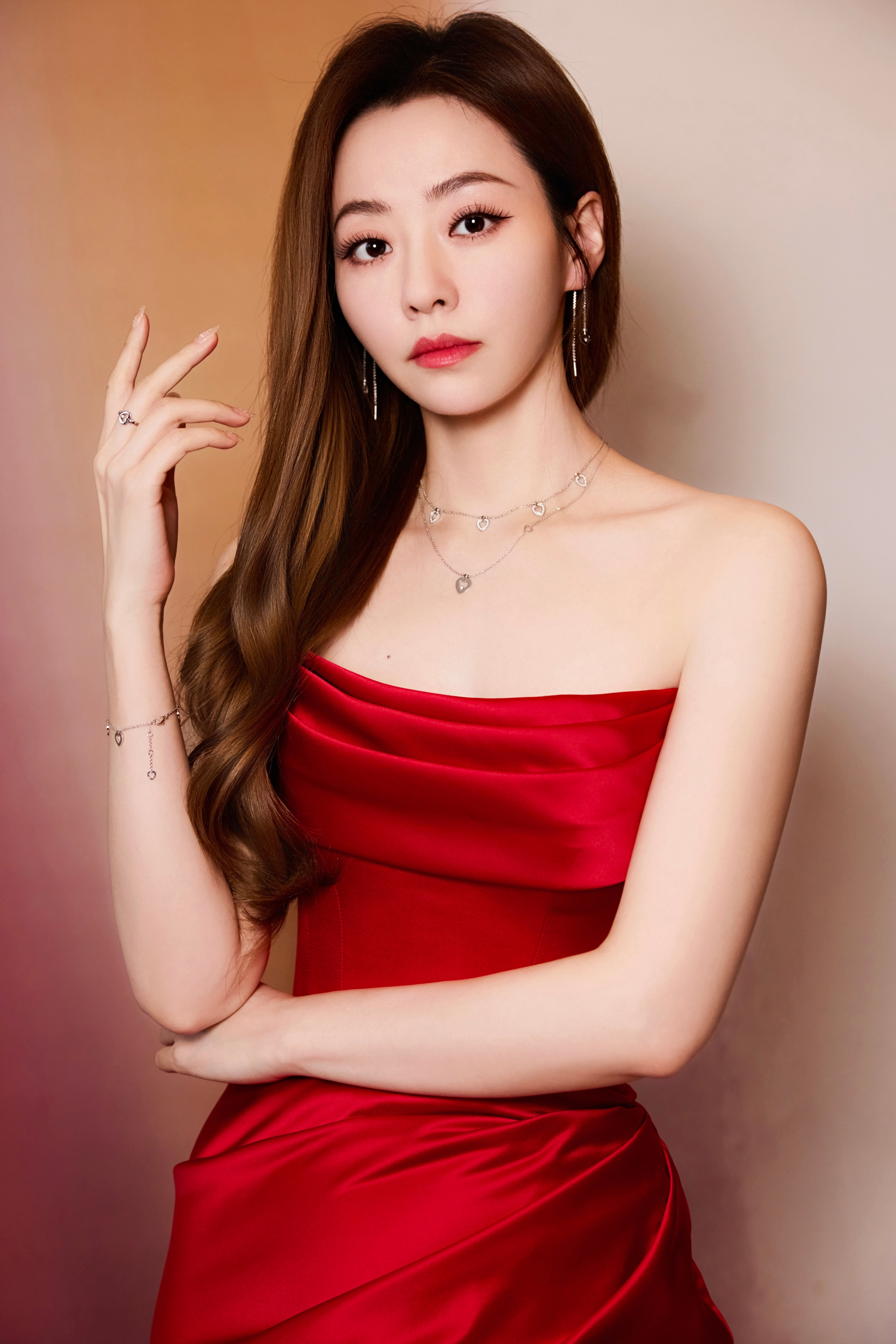 张靓颖一袭正红缎面鱼尾礼裙，抹胸设计衬得肩颈线条优雅，褶皱细节添了几分灵动，如