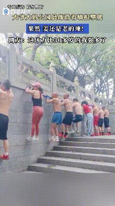 大爷大妈公园晨练沿着墙根进行攀爬，他们持续攀爬近一分钟，未出现疲劳迹象，网友：这
