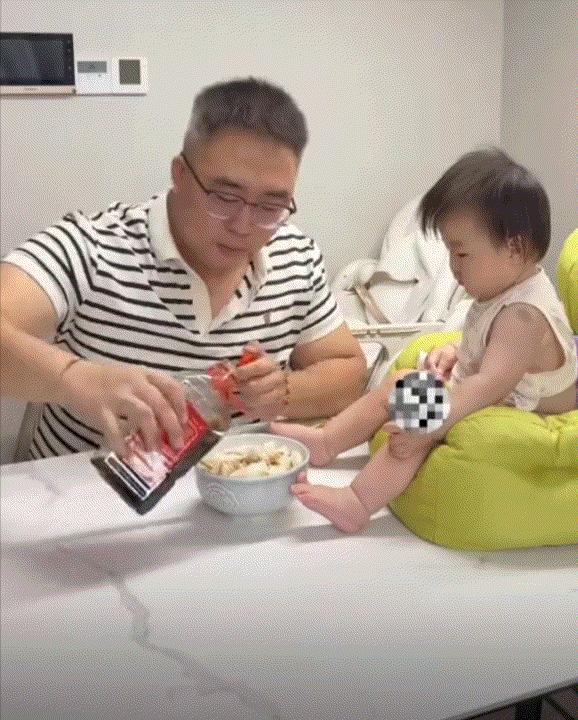 笑不活了！浙江，一爸爸下了一碗面条吃，这宝宝则坐在爸爸面条碗不远处独自玩耍，而爸