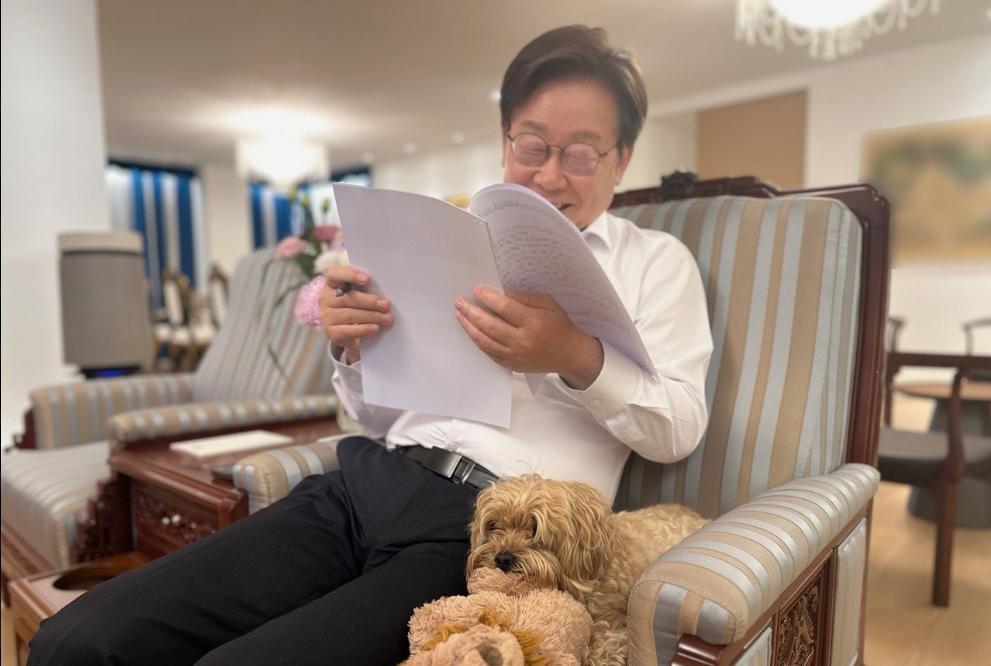 李在明近况照片：坐在办公室的扶手椅上与爱犬芭比合影。时间是7月14日。李在明