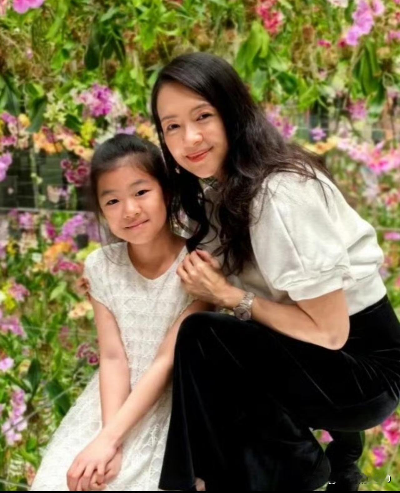 章子怡和10岁的女儿醒醒，依偎在花丛中，留下这温馨的一幕。醒醒从小就被吐槽，颜值