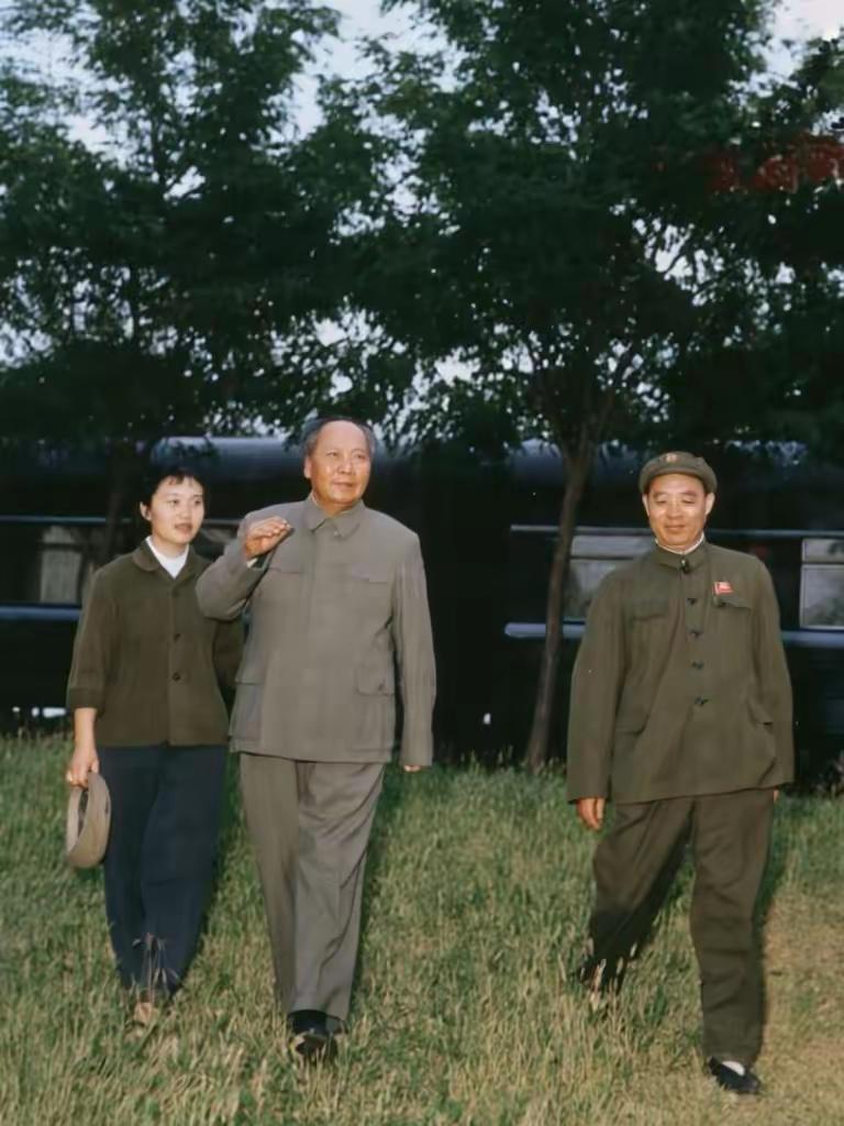 一次视察途中主席和机要秘书张玉凤，中央警卫局负责人汪东兴在专列旁边的在草地上散步