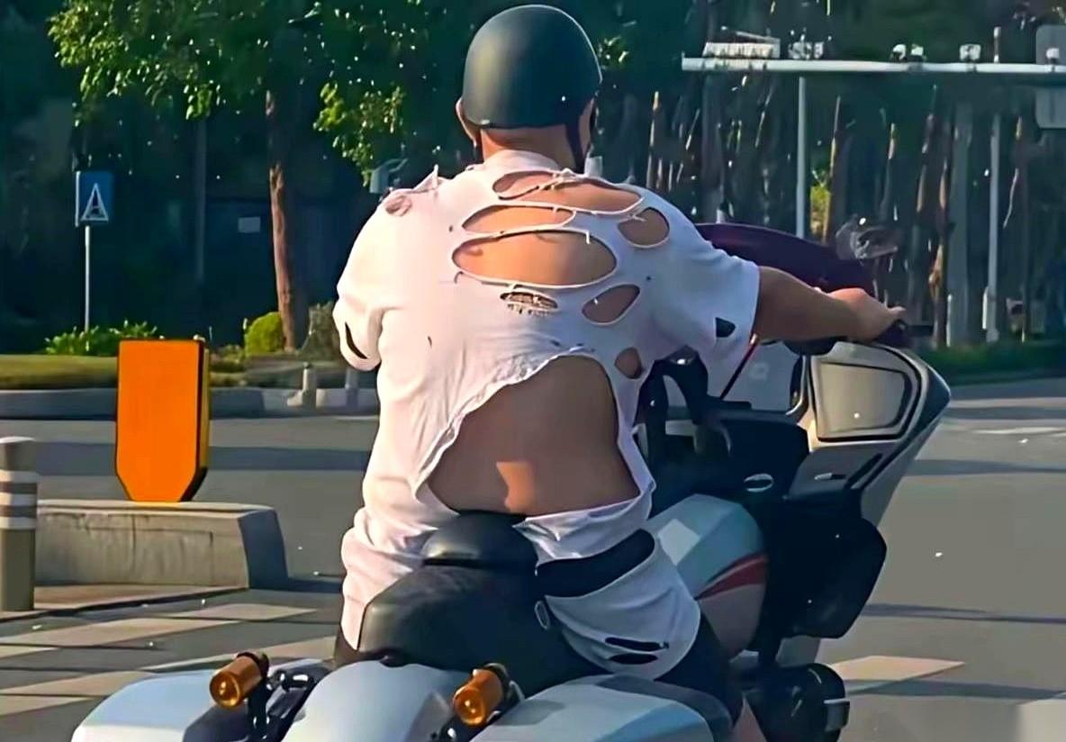 路口等红灯，旁边大哥那件T恤，领口洗得松垮垮，边角还破了几个小洞。我正准备收回