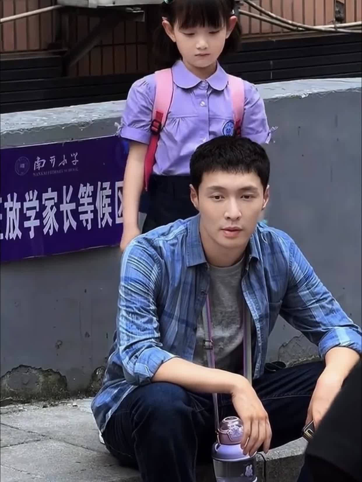演员张艺兴带娃出游，父女俩走累了做路边休息，女儿可爱漂亮。可孩子不觉累，站在爸爸