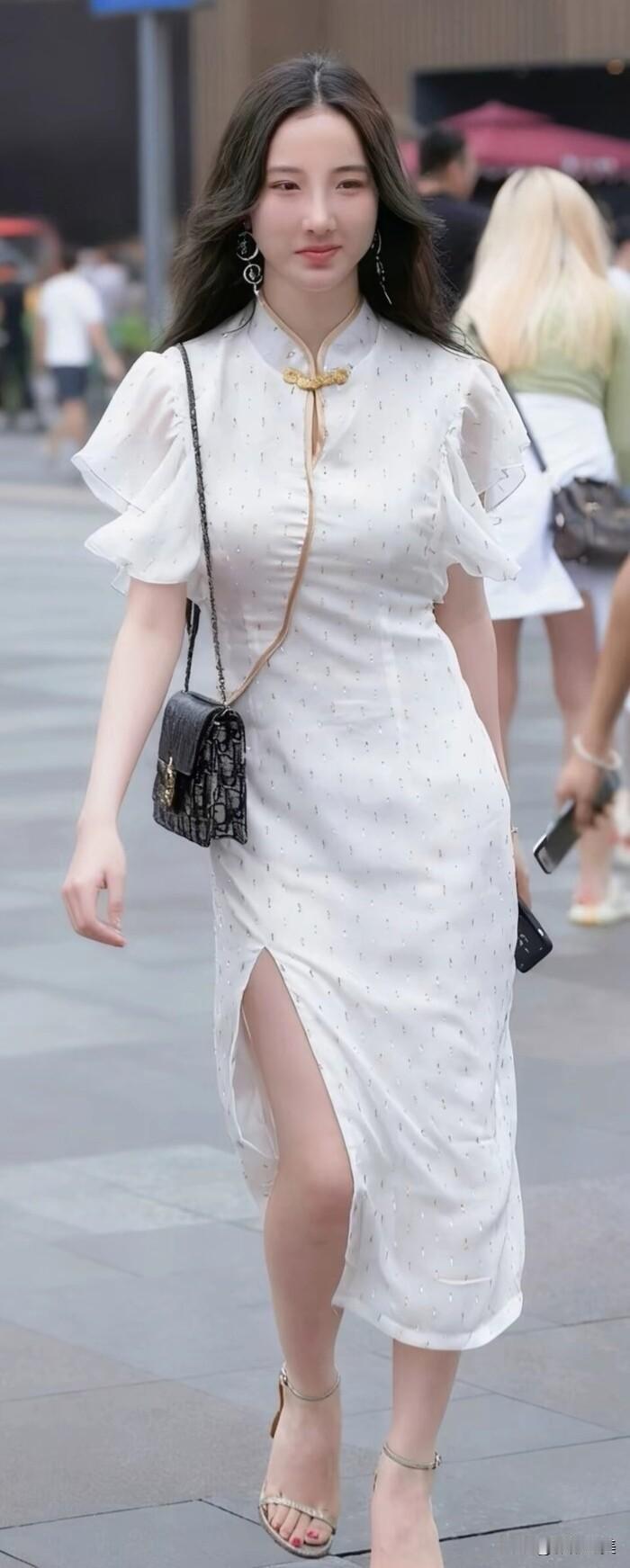街头看到位穿白色旗袍的姑娘，走路带风，笑得好看。这身打扮挺有气质，像电视剧里走出