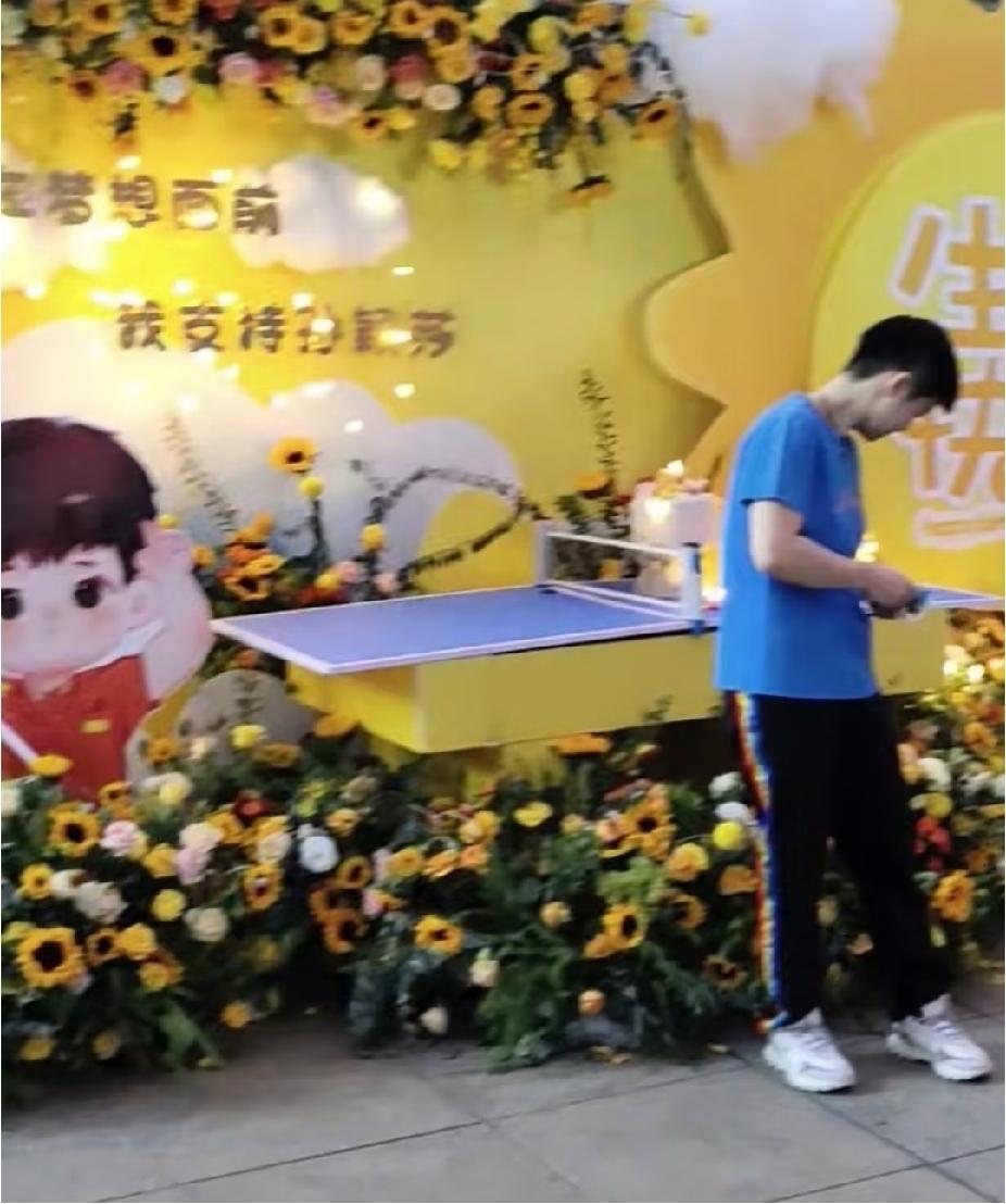 场上小魔王，线下软萌小朋友短发乖乖的，身形看着小小的，站在生日花束旁，稚气