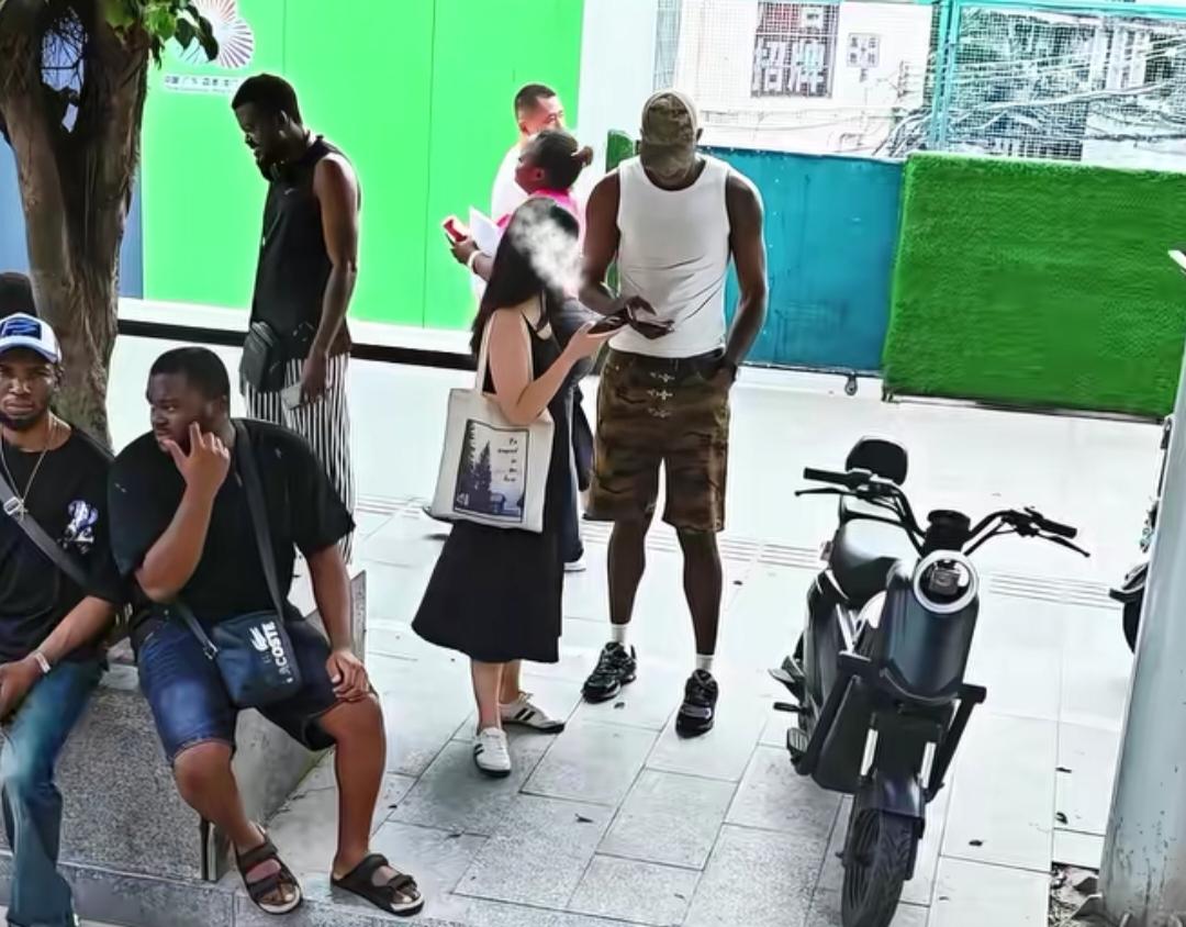 广州街头这一幕，看得人心里真不是滋味。几个黑人男生在路边树底下纳凉，有位小仙女经