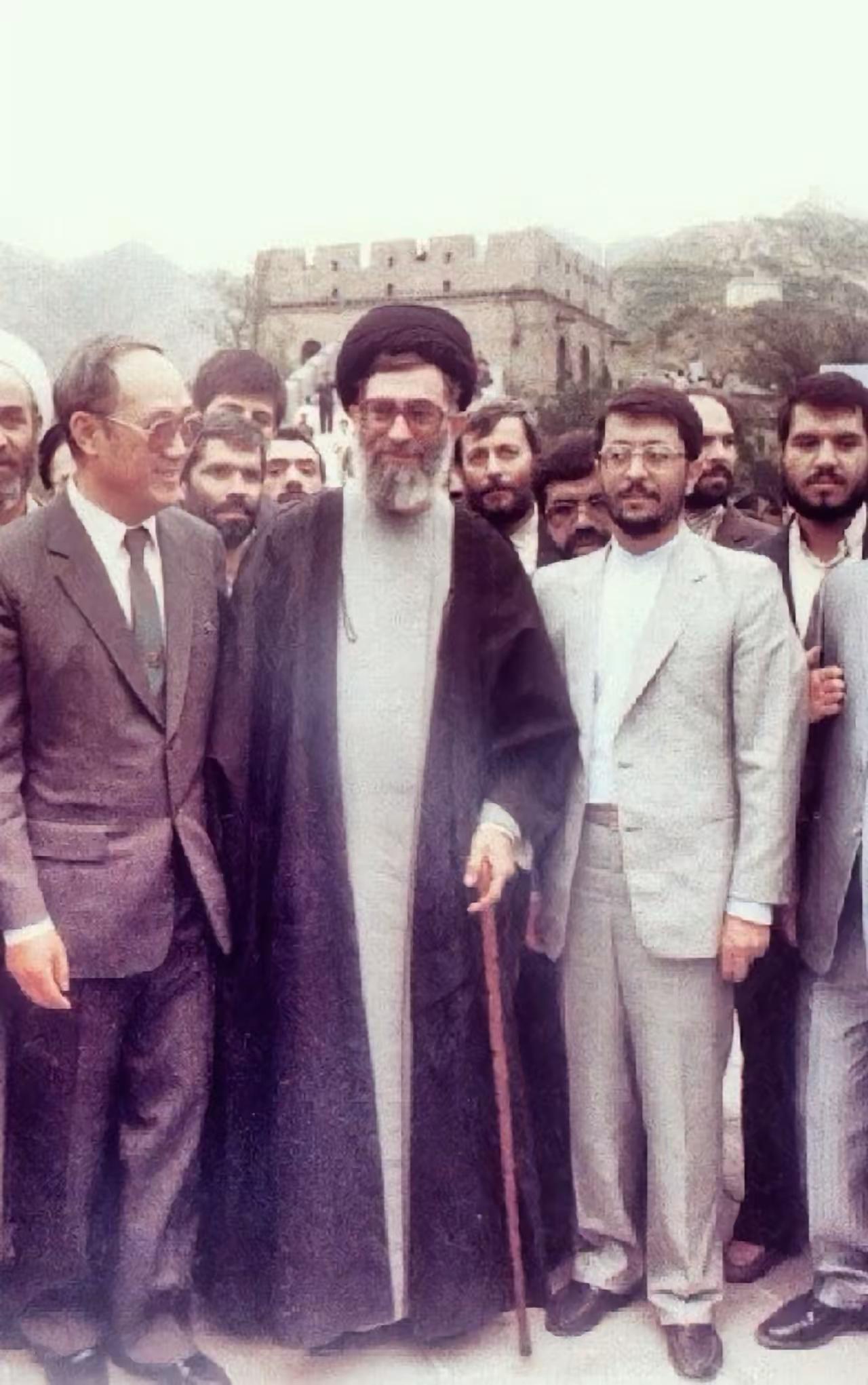 内伊去世。享年87岁。老照片。拄着拐杖，站在长城上与大家合影。这一年，他50