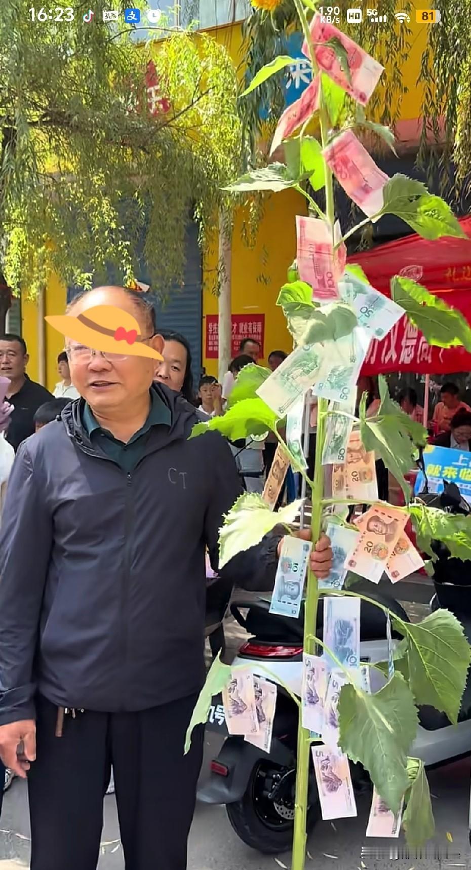 不懂就问，中考现场家长举的向日葵挂这么多人民币是啥意思？中考如期结朿，有网友