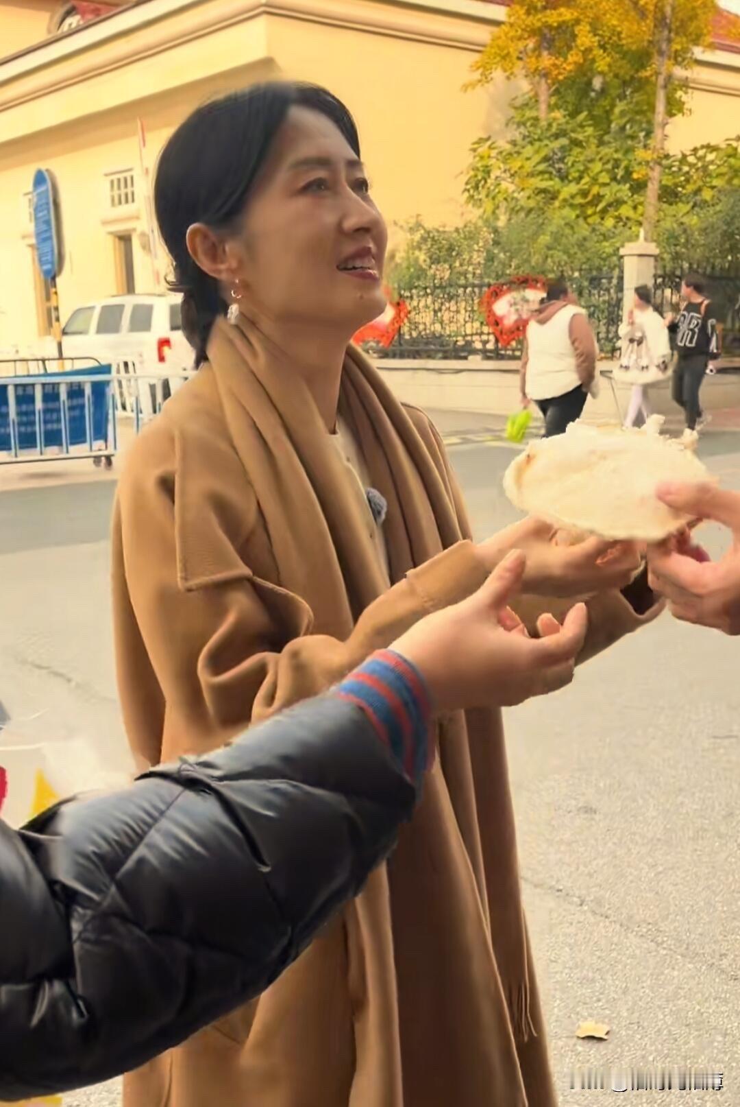 刘敏涛吃的这是什么呀，看着像虾饼呢～～近日，大姐刘敏涛现身烟台街头录节目，驼棕大
