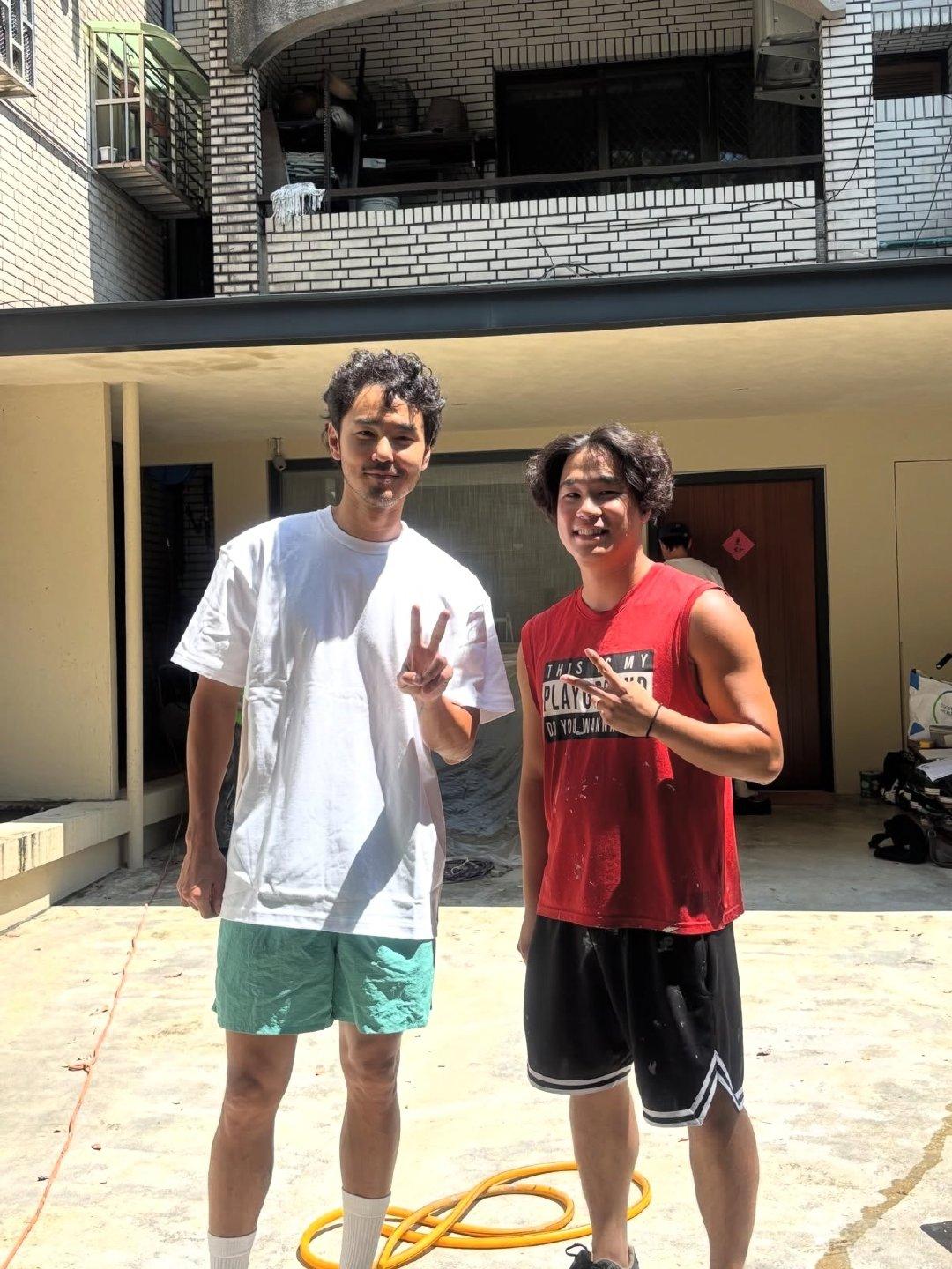 43岁阮经天在中国台湾省的家里和装修工人合照，他穿着一身居家休闲服，胡须没刮，一