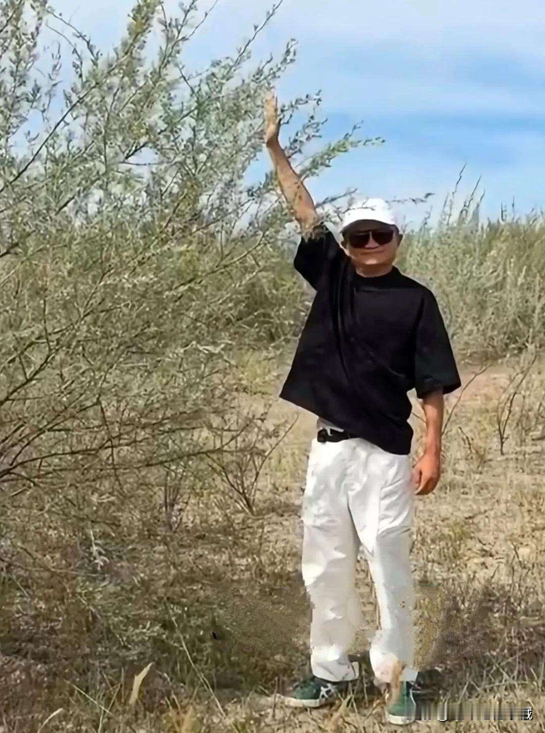近日，马云现身植树山地，戴着白色棒球帽，黑色墨镜，黑圆领T恤衫，白色裤子，绿色平