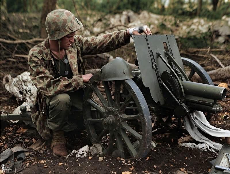 1944年7月，太平洋战场塞班岛，美国海军陆战队第二师一名士兵与其刚缴获的一门日