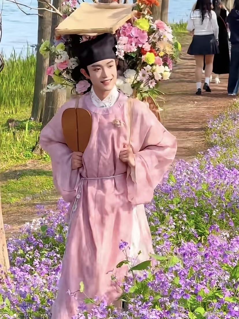 西湖边卖花的小伙子美爆了！这几天，一个美少年火遍全网。一身粉色古装，身背一筐