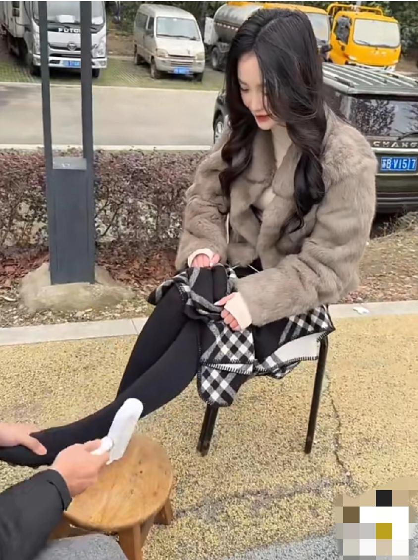 某旅游景区，小伙支起一个小板凳，给这种美女们做足部和腿部按摩。可能是美女们穿高跟