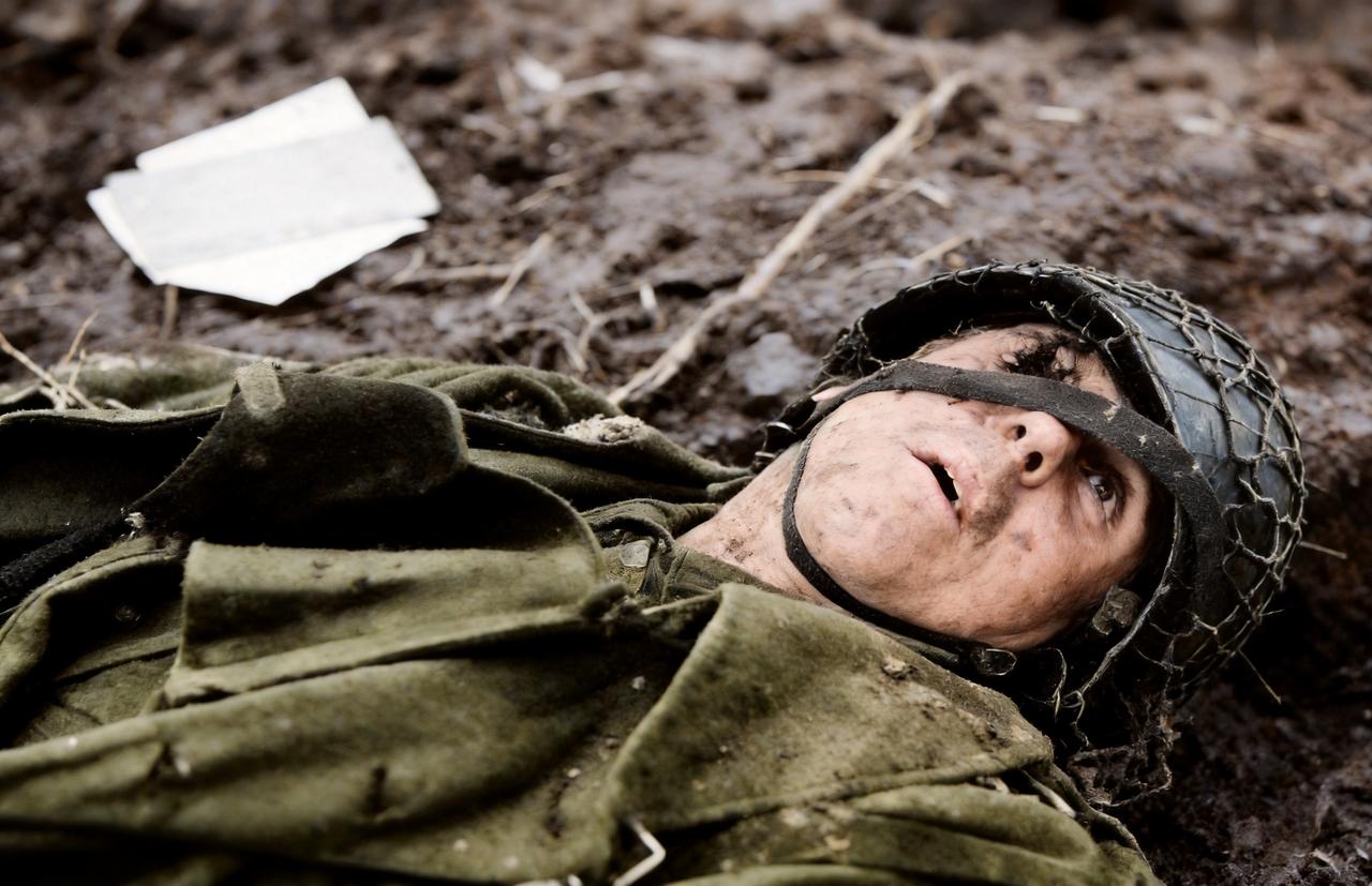 这是1944年12月，一名德军被狙击手击毙。子弹从这名德军的右眼穿过。他的身边还
