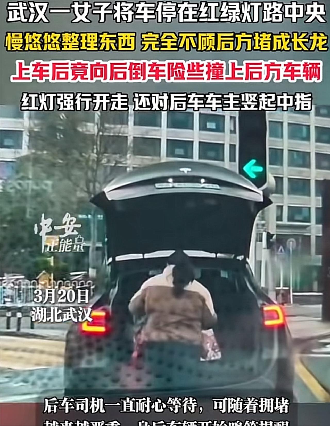 武汉一路口，一名女子驾驶特斯拉挡路停车整理后备箱，随后倒车险些剐蹭后车，接着违规